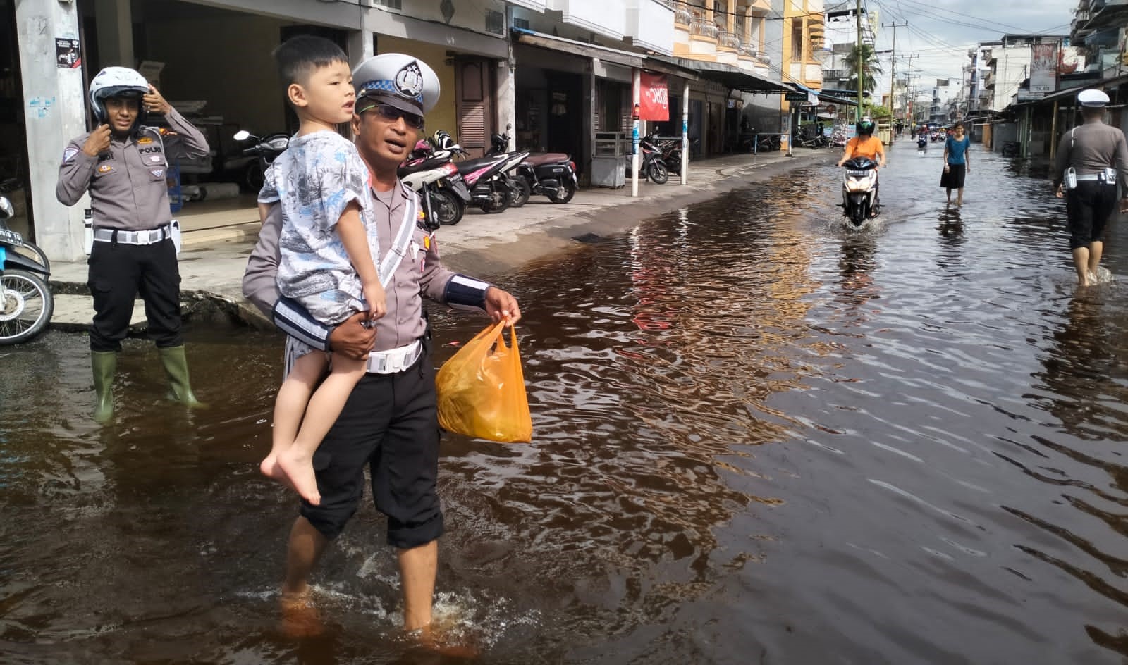 Polantas Kepulauan Meranti Gendong Anak dan Bantu Dorong Motor Mogok Terendam Banjir